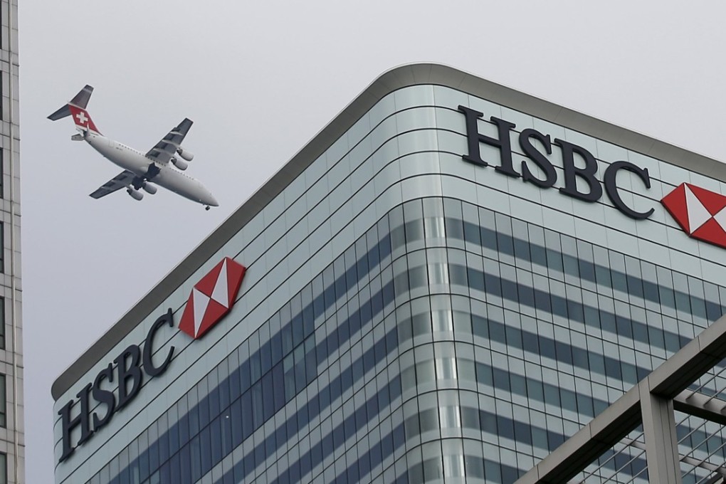 A plane flies past the HSBC headquarters building in Canary Wharf, London. Photo: Reuters