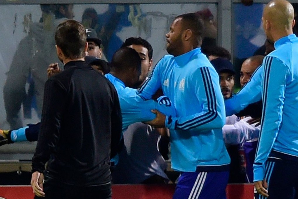 Marseille defender Patrice Evra tries to kick a supporter before the start of the Europa League match against Vitoria SC in Guimaraes. Photo: AFP