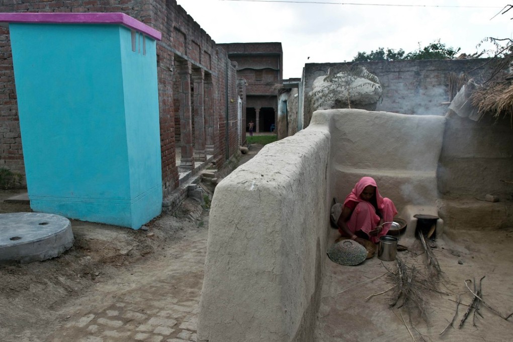 A woman cooks near a new toilet in the village of Katra Sahadatgunj. Photo: AFP