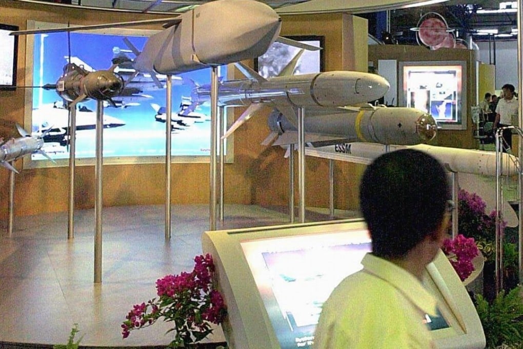 Visitors look at the models of various missles made by Raytheon System Limited on display at the Asian Aerospace 2000 Exhibition and Airshows in Singapore. Photo: AFP PHOTO/Roslan RAHMAN