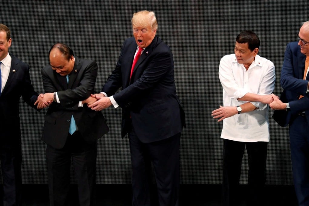 US President Donald Trump registers his surprise as he realises other leaders, including Russia's Prime Minister Dmitry Medvedev, Vietnam's Prime Minister Nguyen Xuan Phuc, President of the Philippines Rodrigo Duterte and Australia's Prime Minister Malcolm Turnbull, are crossing their arms for the traditional ‘Asean handshake’. Photo: Reuters