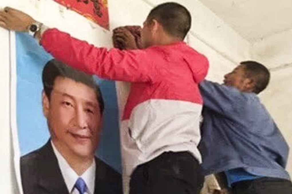 Men put up a poster of Chinese President Xi Jinping in a home in Yugan county, southern China’s Jiangxi province. The local government has launched a campaign to “transform believers in religion into believers in the party”. Photo: Lvv2.com