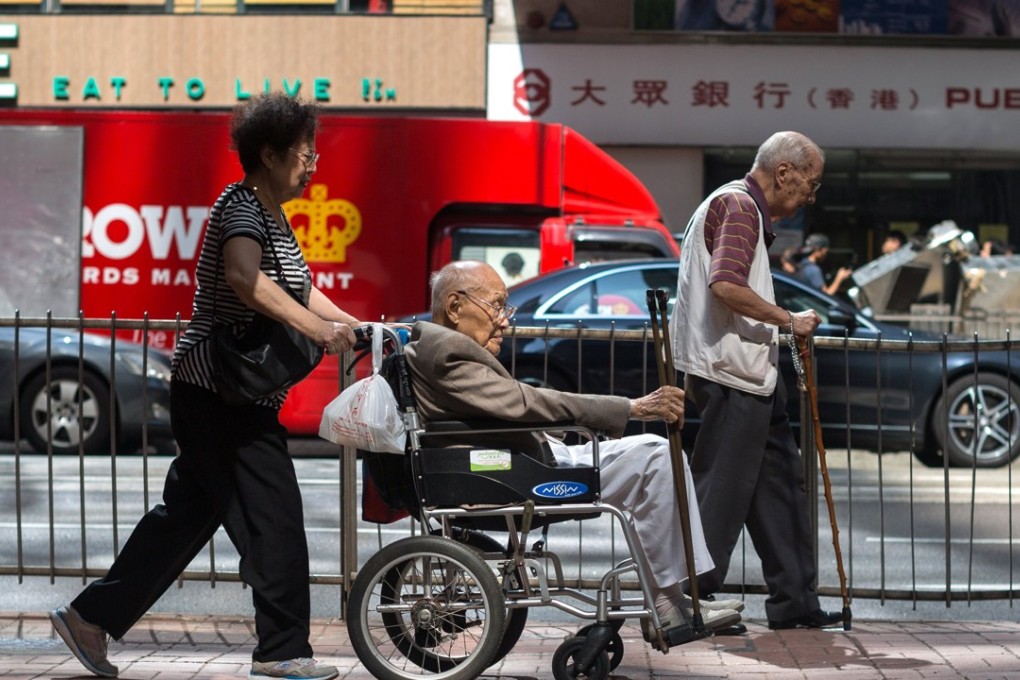 A woman pushes an elderly man on a wheelchair. Photo: EPA