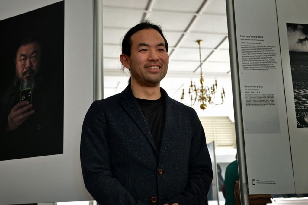 Photographer Stefen Chow with his prize-winning portrait of Chinese artist Ai Wei Wei which is on display at the exhibition, World Press Photo 2013 Singapore. Photo: The Straits Times