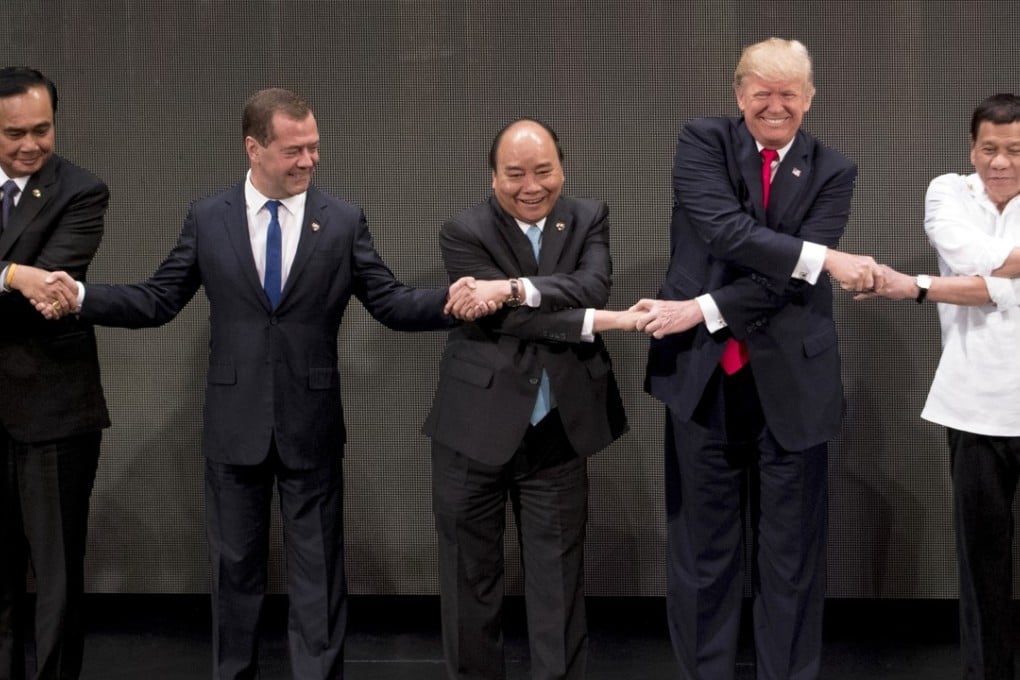 Vietnamese Prime Minister Nguyen Xhan Phuc (centre) joins hands with (from left) Thai Prime Minster Prayuth Chan-ocha, Russian Prime Minister Dmitry Medvedev, US President Donald Trump, and Philippine President Rodrigo Duterte in the “Asean-way handshake” on November 13 in Manila, at the opening ceremony for the Asean Summit. Photo: AP