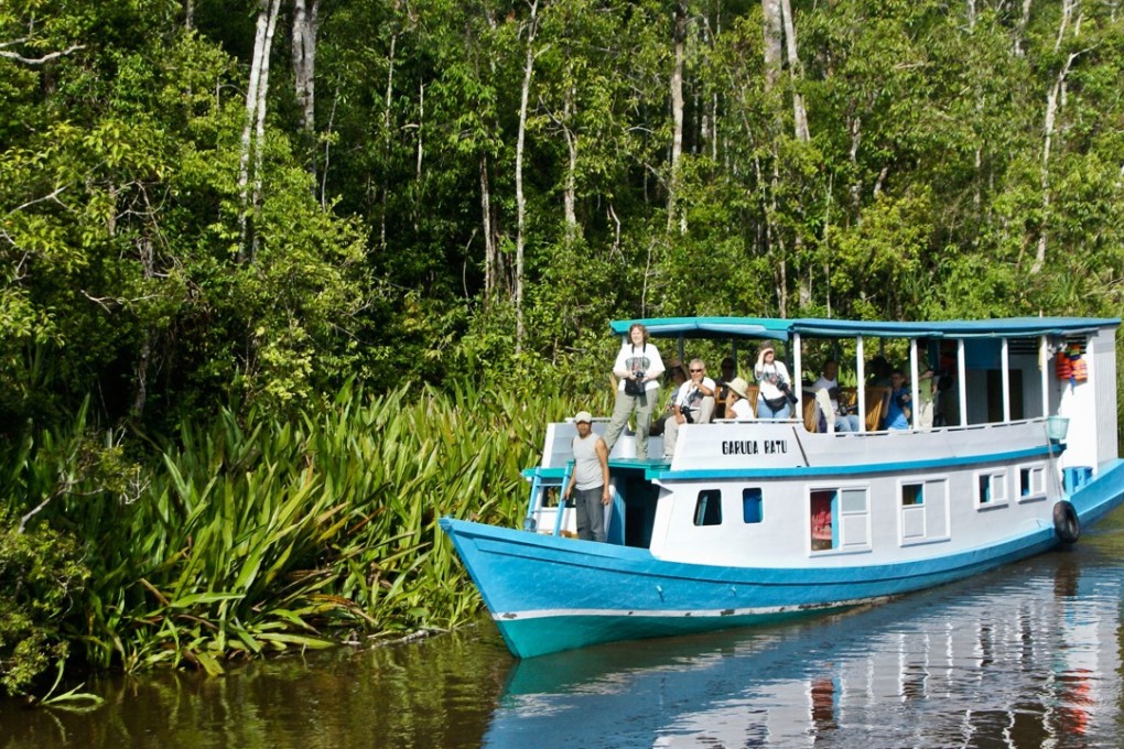 Tourists on a klotok on the Sekonyer River in Borneo, Indonesia. Picture: Alamy