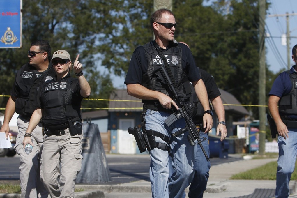 Members of the Tampa Police Department, Bureau of Alcohol, Tobacco, Firearms and Explosives and the Hillsborough County Sheriff's Office work the scene of a fatal shooting in the Seminole Heights neighbourhood in Tampa, Florida, on Tuesday, November 14, 2017. A serial killer is believed to have shot dead four people over the past month. Photo: Tampa Bay Times via AP