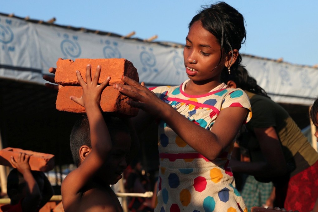 Rohingya refugee children collect bricks at the Balukhali Refugee Camp in Cox's Bazar, Bangladesh, on November 13. The UN’s International Organisation for Migration has warned that, with more than 600,000 Rohingya having fled Myanmar to Bangladesh since August, the refugees are at the mercy of human traffickers in the area. Photo: Reuters