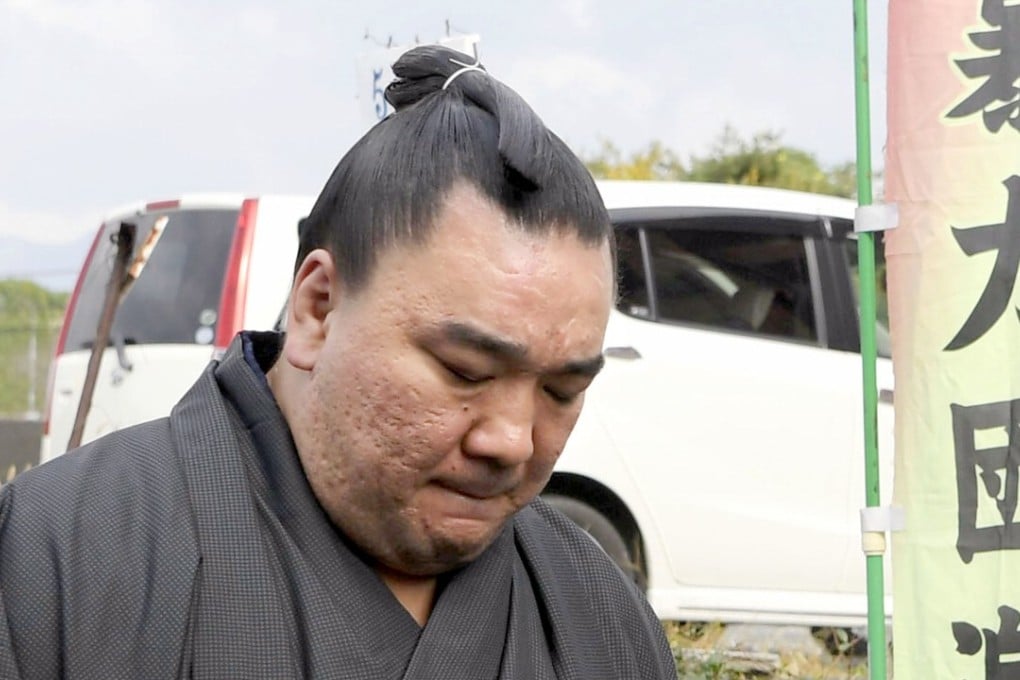 Sumo grand champion Harumafuji looks at the ground as he leaves after visiting wrestler Takanoiwa’s stable master’s quarters in Tagawa, southwestern Japan, to offer an apology. Photo: AP