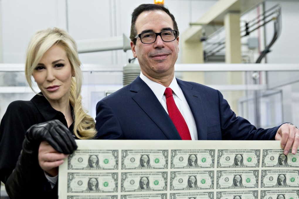 US Treasury Secretary Steven Mnuchin, right, and wife, Louise Linton, hold an uncut sheet of $1 dollar notes. Photo: