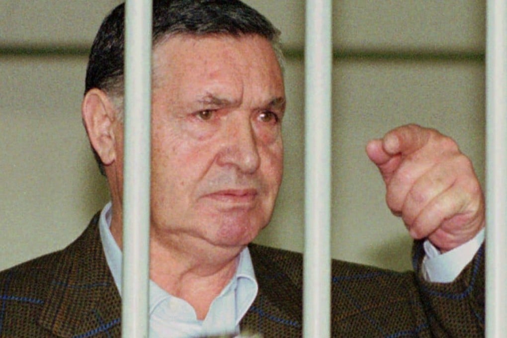 FILE - In this April 29, 1993 file photo, Mafia "boss of bosses" Salvatore "Toto" Riina, is seen behind bars, during a trial in Rome. Italy’s justice minister has given special permission for family bedside visits to the comatose top Mafia boss. Italian media said Riina’s health deteriorated recently after undergoing two recent surgeries. (AP Photo/Giulio Broglio)