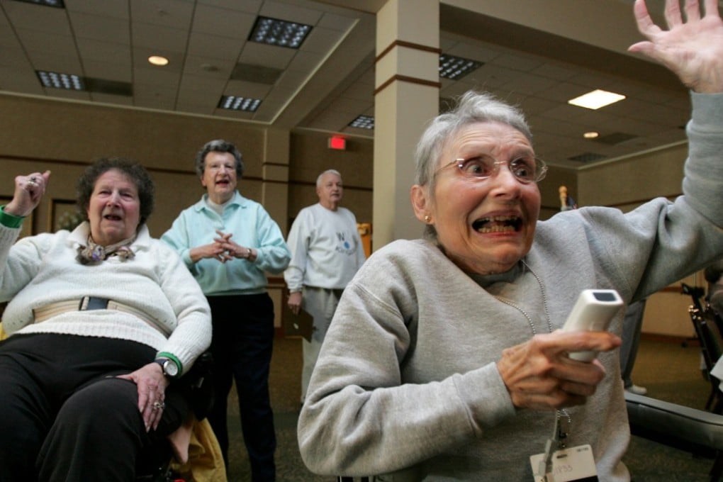 Retirement centre residents react to playing a video game. A new study has shown that the risk of dementia could be reduced by playing video games that exercise the brain. Photo: AFP