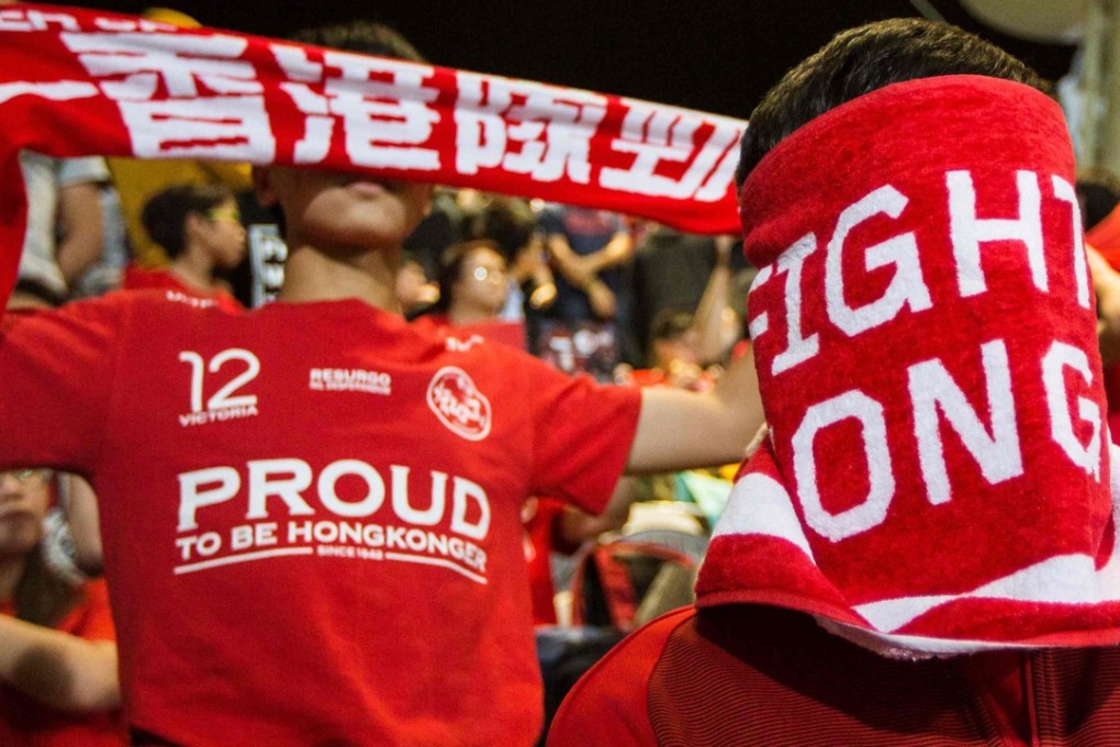A Hong Kong fan covers his face as the Chinese national anthem is booed before a friendly match between Hong Kong and Bahrain at Mong Kok Stadium. Photo: AFP