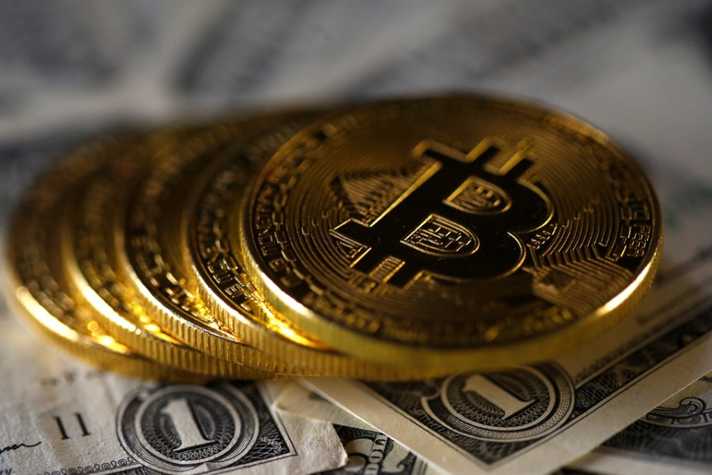 Bitcoins are placed on top of US dollar banknotes. Photo: Reuters