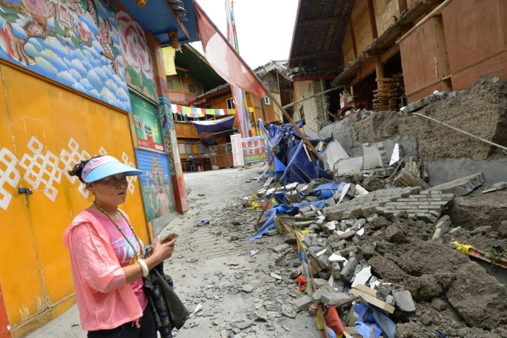 A woman stands in front of a destroyed house in Jiuzhaigou County in Ngawa Tibetan and Qiang Autonomous Prefecture, Sichuan Province, on August 10, 2017, after it was struck by a powerful earthquake on August 8. A 6.3 quake hit southern China on Saturday, November 18, 2017. Photo: Kyodo