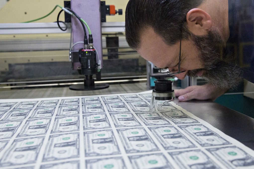 A pressman inspects a stack of 2017 50 uncut sheets of US$1 dollar notes. The dollar is on track to post its biggest weekly loss in more than a month. Photo: Bloomberg