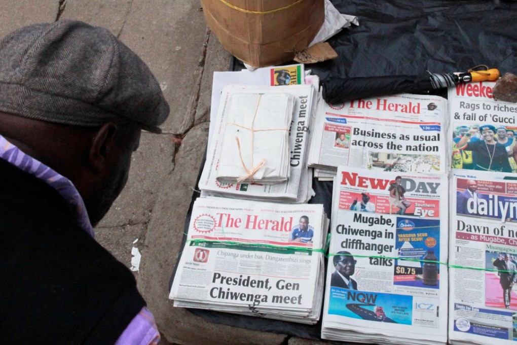 A man reads the headlines of newspapers for sale on a street in Harare, Zimbabwe. Photo: Reuters