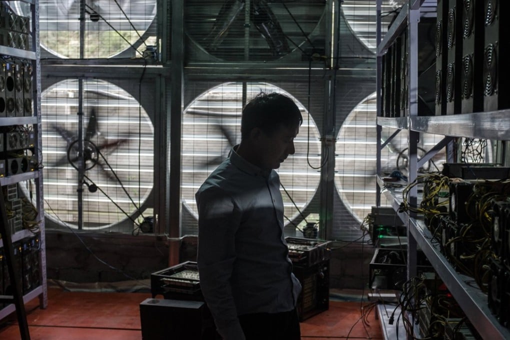 A bitcoin mine owner surnamed Liu, 29, stands in front of a wall of cooling fans at the facility where he houses and operates mining machines in rural Sichuan. Photo: EPA