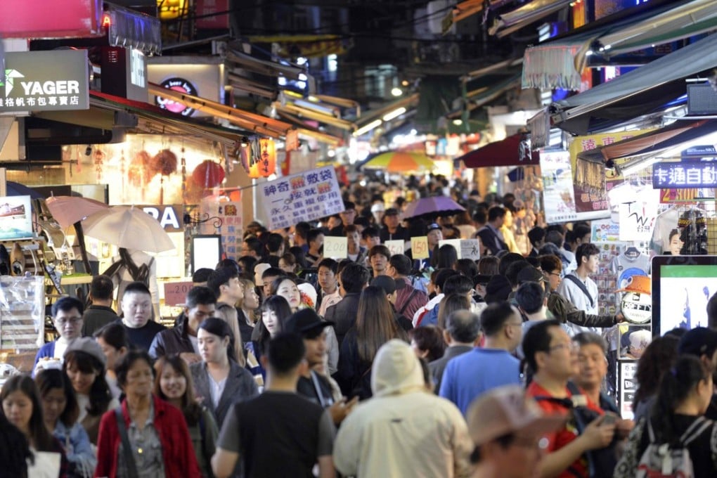 People visit the Shilin night market in Taipei for some of its famous street food. Photo: AFP