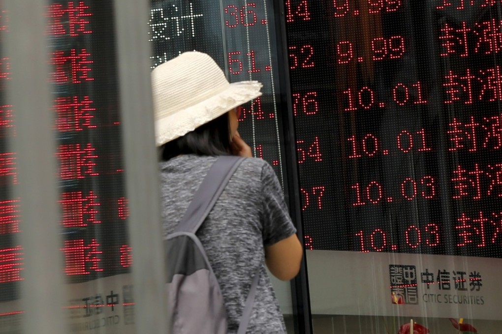 A woman outside a brokerage house displaying stock prices in Beijing. Photo: AP