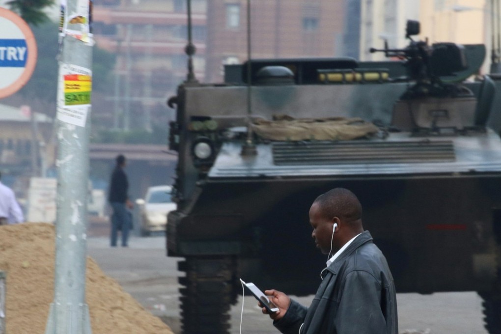 A Harare resident seemed more concerned with his mobile phone than the presence of troops on the streets of the capital on Friday. Photo: Reuters