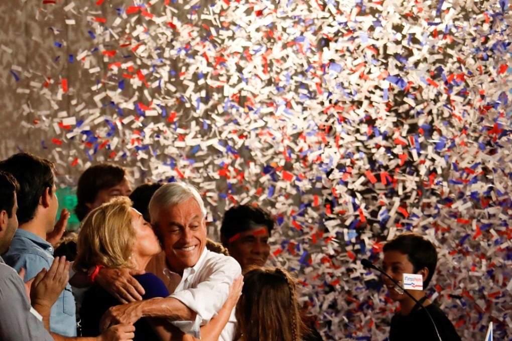 Chilean presidential candidate Sebastian Pinera and his wife Cecilia kiss during a gathering with supporters after leading the first round of general elections in Santiago on Sunday. Photo: Reuters
