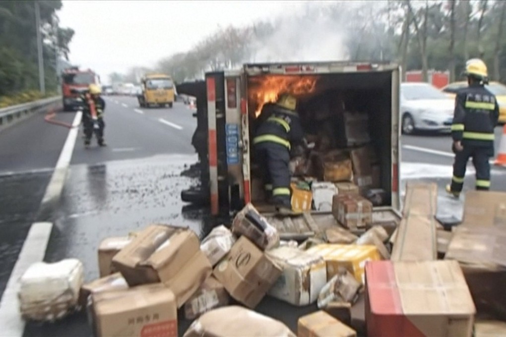 A firefighter is seen throwing packages from the burning truck in this still from the video. Photo: CCTV
