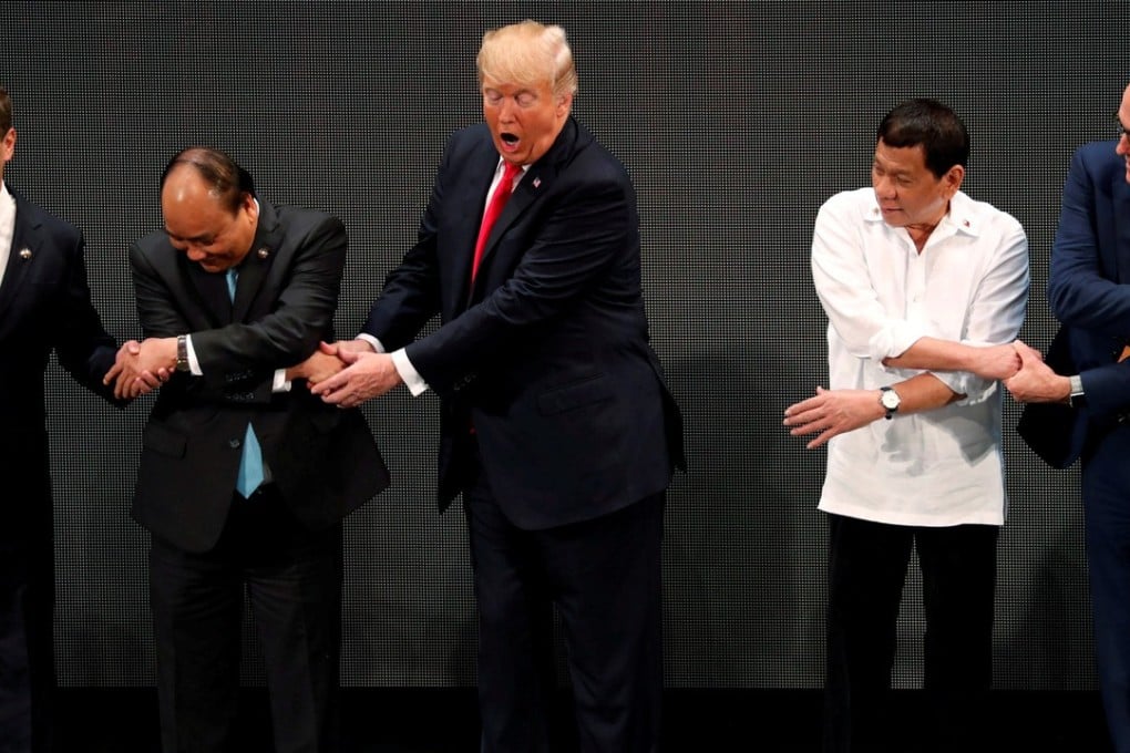US President Donald Trump fumbles during the traditional “Asean handshake” with leaders including (from left) Russian Prime Minister Dmitry Medvedev, Vietnam’s Prime Minister Nguyen Xuan Phuc, Philippine President Rodrigo Duterte and Australian Prime Minister Malcolm Turnbull, in Manila on November 13. Photo: Reuters