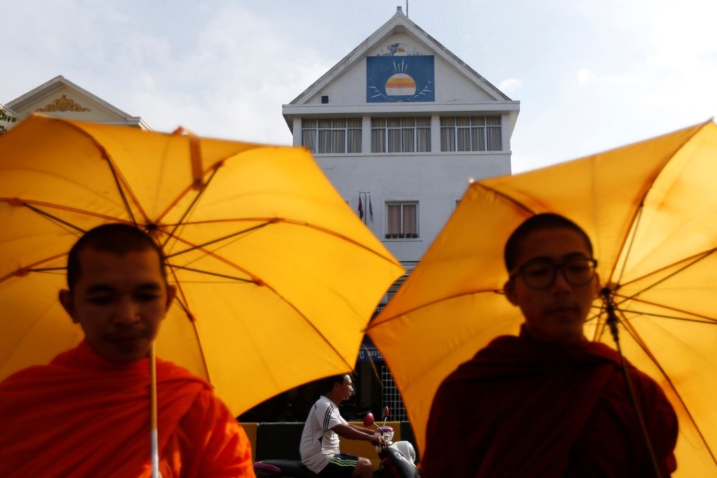 Buddhist monks stand in front of the Cambodia National Rescue Party headquarters in Phnom Penh, Cambodia, on Friday. Photo: Reuters