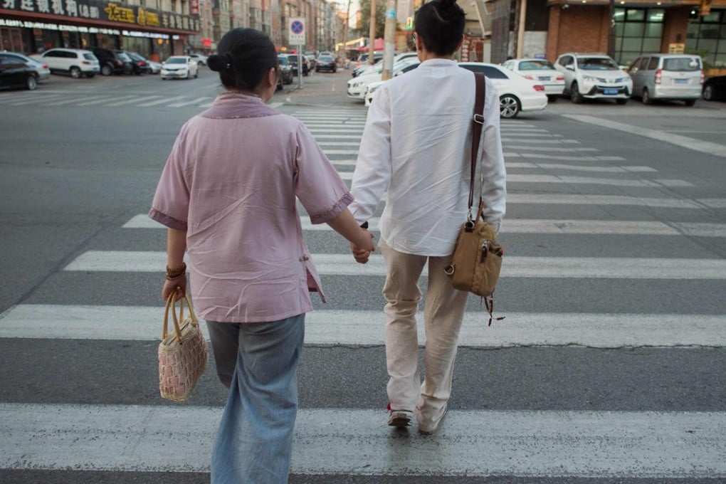 Xiaojing (left) and Xiaoxiong cross a road in Shenyang, where they live together. Photo: AFP