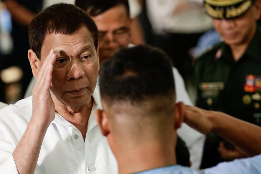 Philippine President Rodrigo Duterte salutes a wounded soldier at a hospital in Taguig, south of Manila. Photo: EPA
