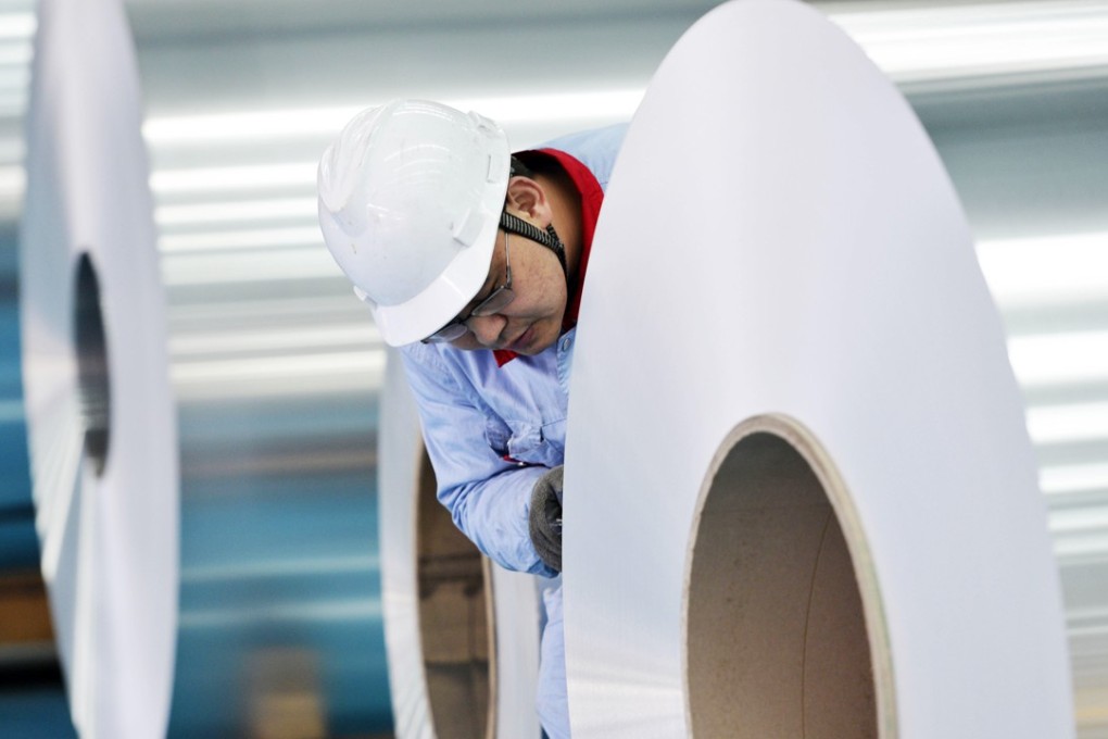 A Chinese worker checks coiled aluminium plates at Shandong Weiqiao Pioneering Group Co in Zouping county in east China's Shandong province. Photo: Imaginechina