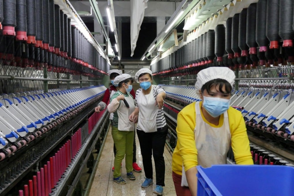 A worker rolls away carts of unused tools between rows of spinning machines at a factory in Zhuhai City, in Guangdong province. Asia’s labour market needs to be more efficient and flexible to match people with the right jobs. Photo: Reuters