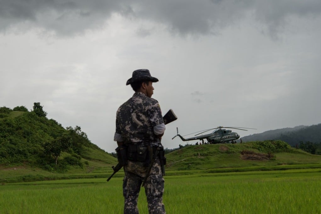 A policeman stands guard near a military transport helicopter at Ye Baw Kyaw village in Rakhine state. Myanmar’s armed forces have been accused of a string of human rights violations during their campaign against Rohingyq rebels in the region. Photo: AFP/STR