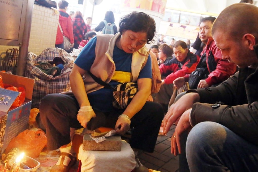 A “villain hitter” pounds a paper effigy with a shoe under the Canal Road flyover, in Wan Chai, on March 6, 2015. Picture: SCMP
