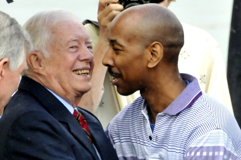 Former US President Jimmy Carter, left, hugs fellow American Aijalon Gomes at Pyongyang airport, North Korea, on Friday August 27, 2010, after securing his release. Photo: AP