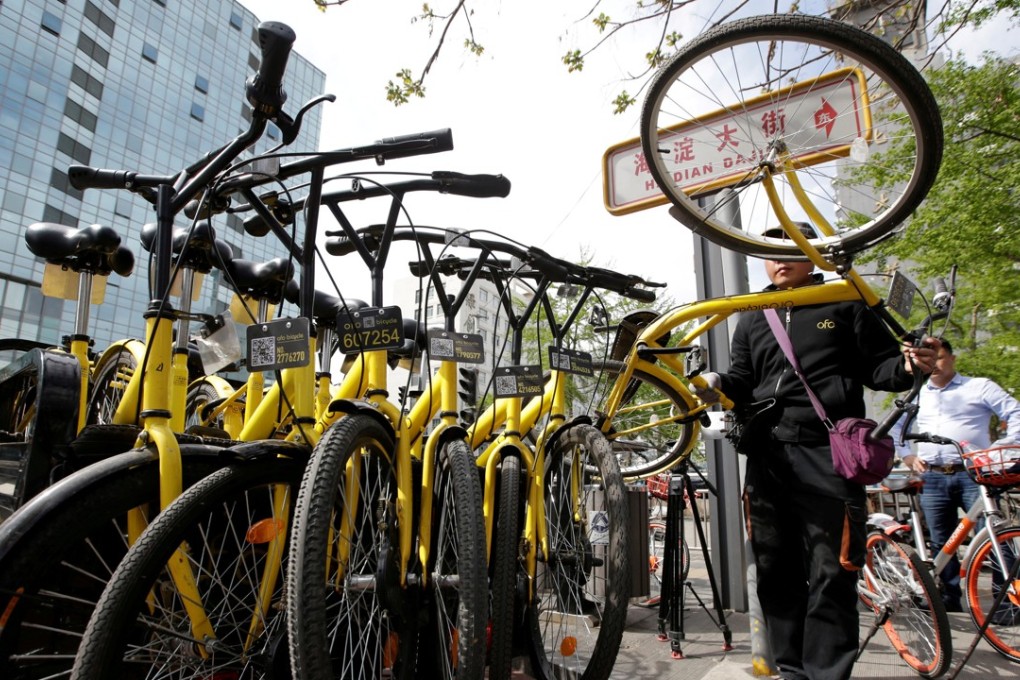 A staff member from Ofo gathers its shared bikes for use during the evening rush hour in Beijing. Ofo and competitor Mobike account for 95 per cent of the bike sharing market, leaving little room for others. Photo: Reuters