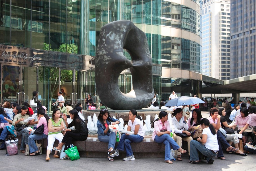 Domestic Helpers from the Philippines enjoy time off at Exchange Square in Central. Photo: Alamy