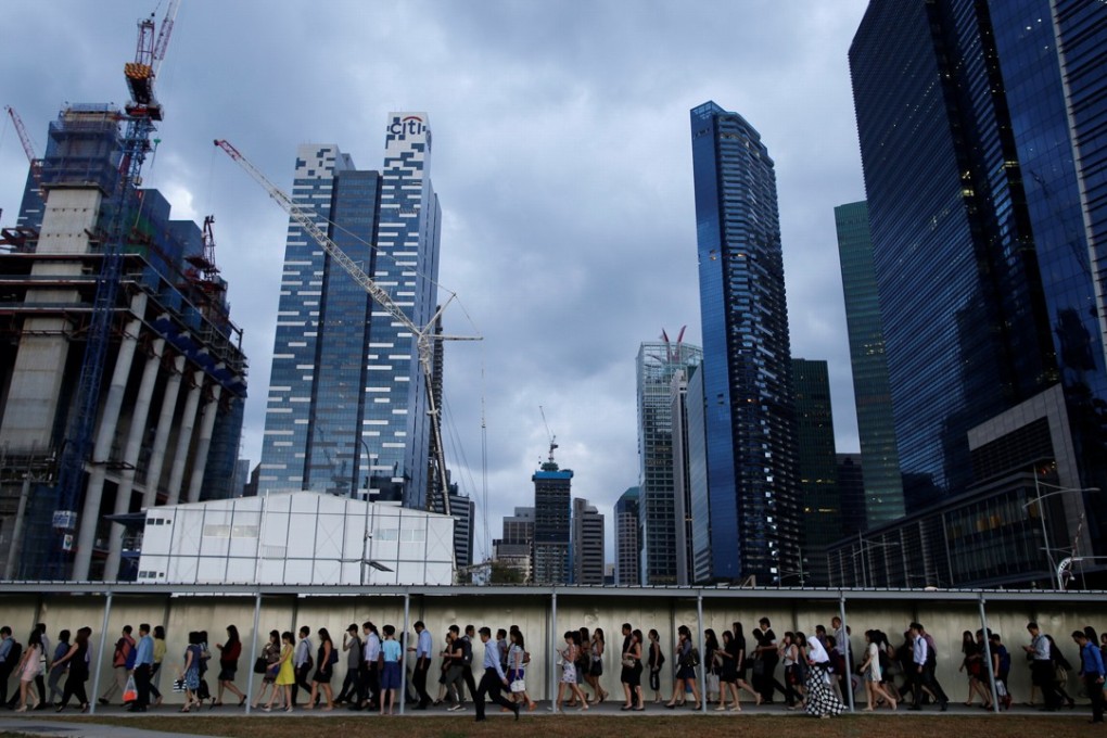 Office workers walk to the train station during evening rush hour in the financial district of Singapore. Photo: REUTERS/Edgar Su