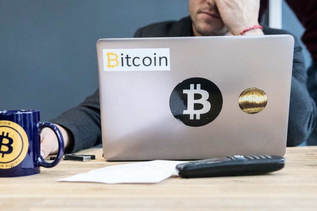 An employee uses a laptop computer branded with bitcoin logos inside the offices of a bank in France. Photo: Bloomberg