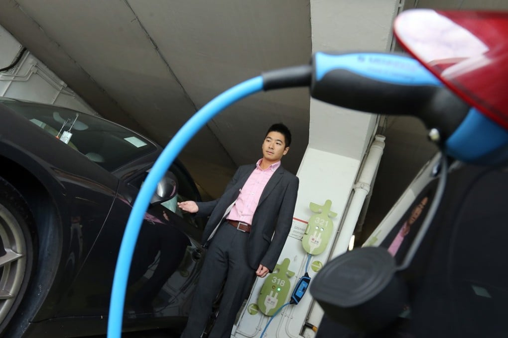 Eric Tang charges his electric vehicle at a station in the Star Ferry car park in Central district. Most drivers in Hong Kong have to go to public car parks to recharge vehicles, and an insufficient number of such car parks means they often have trouble finding public charging stations. Photo: Dickson Lee