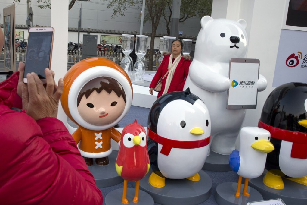A woman takes photos near mascots for various social media platforms owned by Tencent Holdings. The internet giant lost US$16.5 billion in market cap on Thursday. Photo: AP