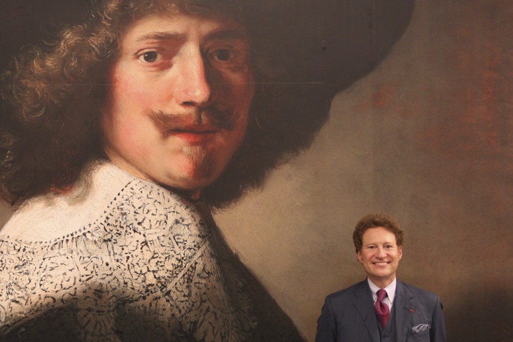 Thomas Kaplan with a poster of one of his paintings, Portrait of Antonie Coopal, by Rembrandt van Rijn and workshop, at the Long Museum, in Shanghai. Picture: Simon Song
