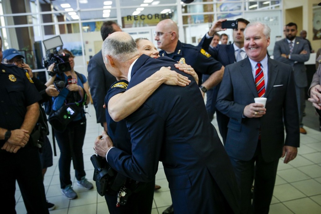 Florida Governor Rick Scott hugs Tampa Police Officer Randi Whitney, the officer credited with the arrest of Howell Emanuel Donaldson, a 24-year-old Tampa resident charged with four counts of first-degree murder. Photo: AP