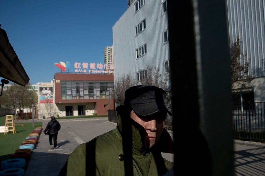 A security guard at the front gate of the RYB Education New World kindergarten in Beijing. Chinese police have launched an investigation into alleged child abuse at a preschool after parents said toddlers were jabbed with needles and given mysterious pills. Photo: AFP