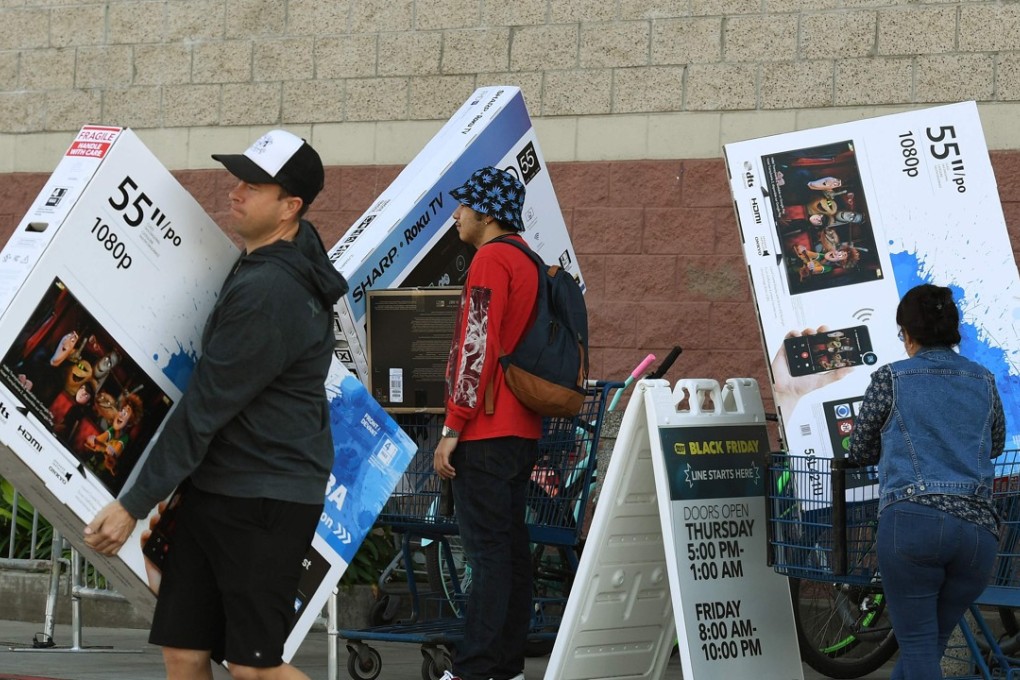 Shoppers with their arms full walking to their cars during the “Black Friday” sales at a Best Buy store. The US economy expanded at its fastest pace in three years. Photo: AFP