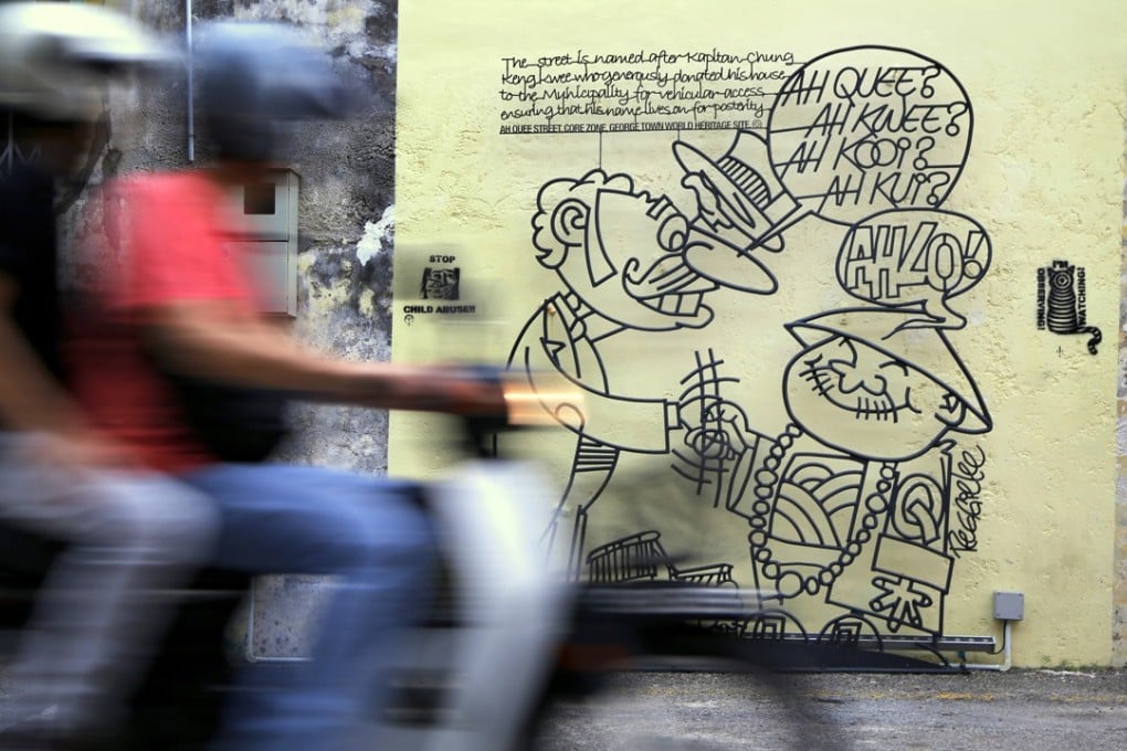 A motorbike speeds past a steel-rod sculpture describing the history of George Town on the island of Penang, Malaysia. Photo: Adam Shreck