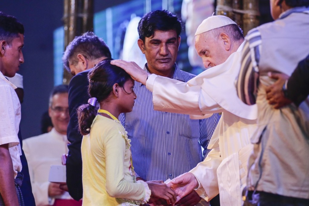 Pope Francis consoles a Rohingya orphan girl during a meeting at the garden of the Archbishop in Dhaka, Bangladesh. Photo: EPA