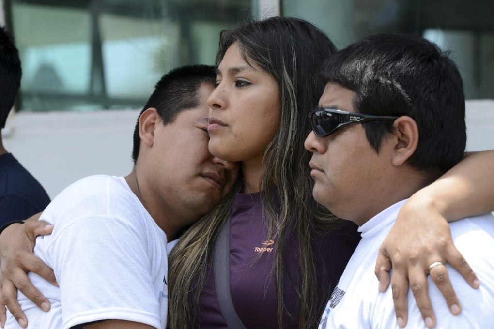 Relatives one of the crew member of the missing ARA San Juan submarine hug outside the navy base in Mar del Plata. Photo: AP