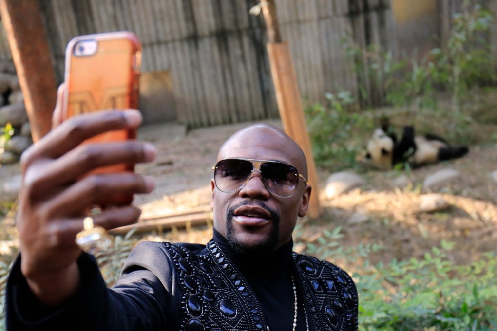Floyd Mayweather Jnr takes a selfie with his adopted ‘TMT Floyd Mayweather’ at the Chengdu Research Base of Giant Panda Breeding while on his luxury vacation in China. Photo: AFP